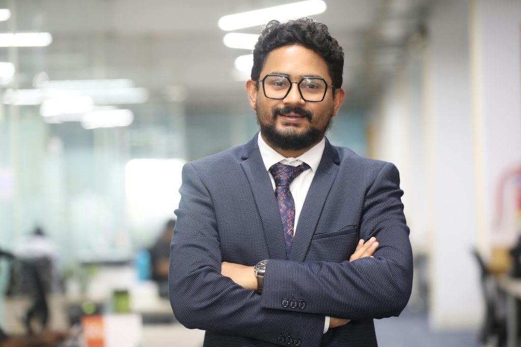 Confident man in a suit standing in a modern office, showcasing professionalism.