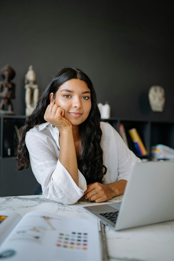Portrait of a confident businesswoman working at her desk with a laptop in an office setting.